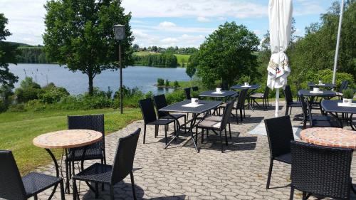 eine Reihe von Tischen und Stühlen mit Seeblick in der Unterkunft Hotel am Untreusee in Hof