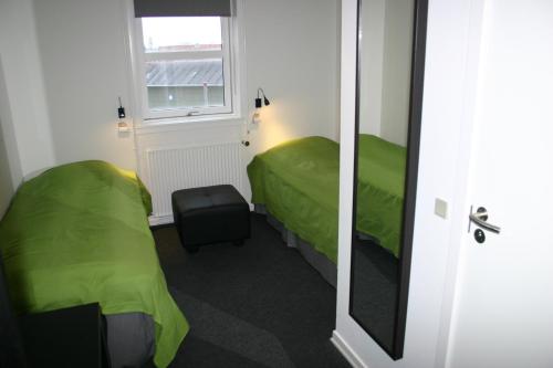 um pequeno quarto com 2 camas e um espelho em Danhostel Svendborg em Svendborg