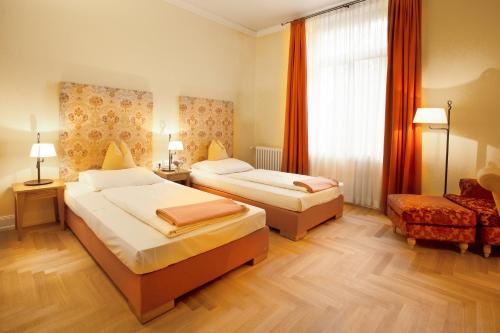 a hotel room with two beds and a window at Hotel Villa Florentina in Frankfurt/Main