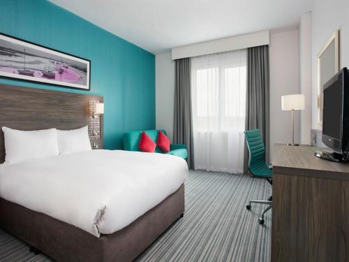 a hotel room with a large bed and a television at Leonardo Hotel Southampton in Southampton