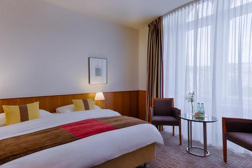 een hotelkamer met een groot bed en een raam bij K+K Palais Hotel in Wenen