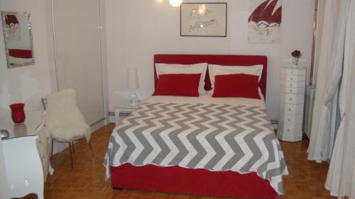 een slaapkamer met een rood-wit bed en een stoel bij Apartments Vodice Marica in Vodice