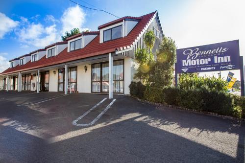 een motel met een bord voor een gebouw bij Bennetts Thermal Motor Inn in Tauranga