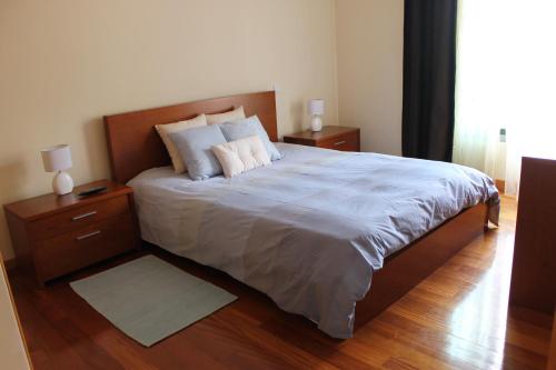 een slaapkamer met een groot bed met 2 nachtkastjes bij Cozy and Bright Apartment in Machico