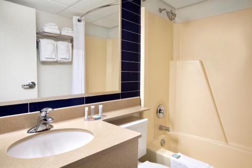 y baño con lavabo, aseo y espejo. en Travelodge by Wyndham Edmonton West, en Edmonton