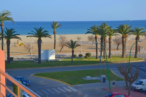 - une vue sur un parking avec des palmiers et la plage dans l'établissement Mirablau, à Empuriabrava