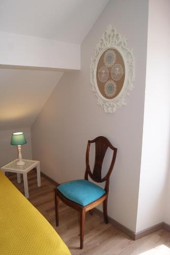 une chambre avec une chaise et une table avec une lampe dans l'établissement O Forte Guest House, à Peniche