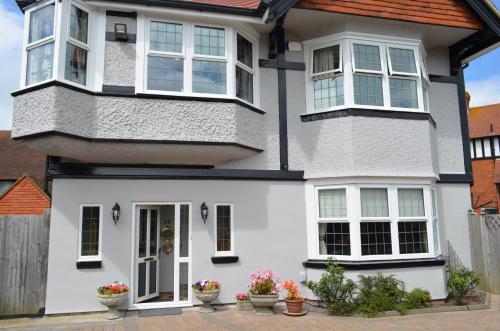 Casa blanca con ventanas blancas y macetas en Foy House, en Folkestone