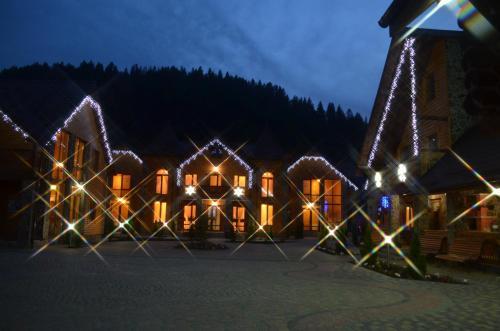 een huis versierd met kerstverlichting 's nachts bij Sribni Rosy in Mykulychyn