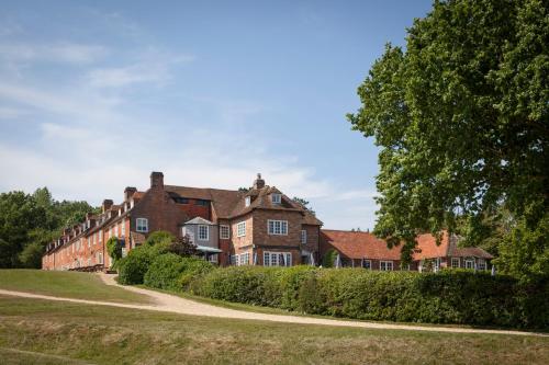 a large brick house with a tree in front of it at Master Builder's House Hotel in Beaulieu