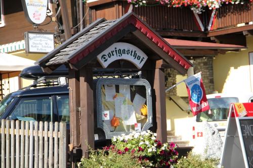 un petit bâtiment avec un panneau indiquant un restaurant dans l'établissement Hotel Dorfgasthof Schlösslstube, à Stuhlfelden