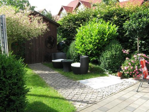 einen Garten mit einer Reihe von Stühlen und Pflanzen in der Unterkunft Ferienwohnung Am Kapellenäcker in Neumarkt in der Oberpfalz