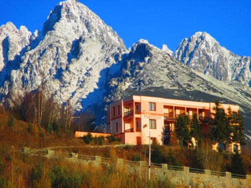 un edificio frente a una montaña en Penzion Partizan, en Vysoke Tatry - Horny Smokovec