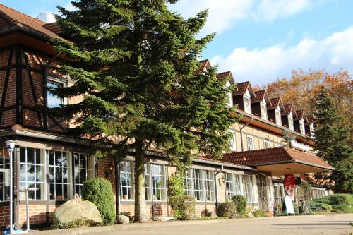 a large building with a tree in front of it at Haags Hotel Niedersachsenhof in Verden