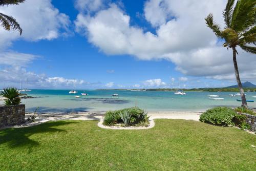 uma vista para uma praia com barcos na água em Turquoise Bay Beach Apartments Trou d'Eau Douce em Trou dʼ Eau Douce