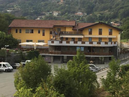 un grande edificio giallo con auto parcheggiate in un parcheggio di Hotel Castello a Montjovet