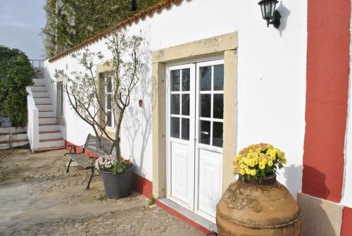 un bâtiment blanc avec une porte et des fleurs dans un pot dans l'établissement Quinta de Sao Filipe, à Setúbal