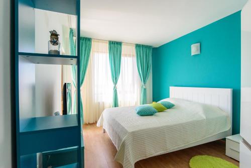 Dormitorio azul con cama y ventana en Villa Maja, en Varna