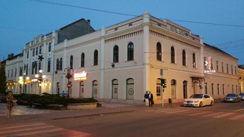 a large white building on the corner of a street at Hotel Dacia in Lugoj