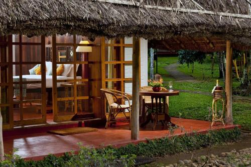 een kleine hut met een tafel en een bed bij Spice Village Thekkady - a CGH Earth Experience in Thekkady