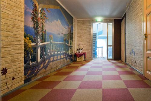 a hallway with a painting on the wall and a checkered floor at Hotel Neun 3/4 in Celle