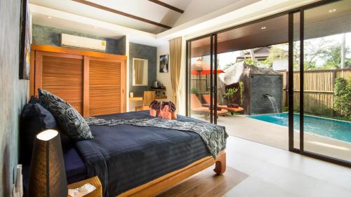 sypialnia z łóżkiem i basenem w obiekcie Khwan Beach Resort - Luxury Glamping and Pool Villas Samui - Adults Only - SHA Extra Plus w mieście Mae Nam