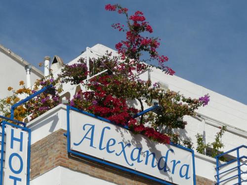 um sinal com flores na lateral de um edifício em Hotel Alexandra Sitges em Sitges