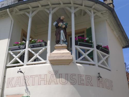 uma estátua de um homem ao lado de um edifício em Hotel Karthäuser Hof em Flörsheim am Main