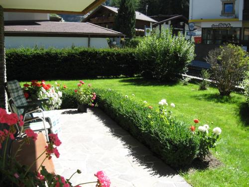 a garden with a bench and some flowers and bushes at Haus Kristall in Längenfeld