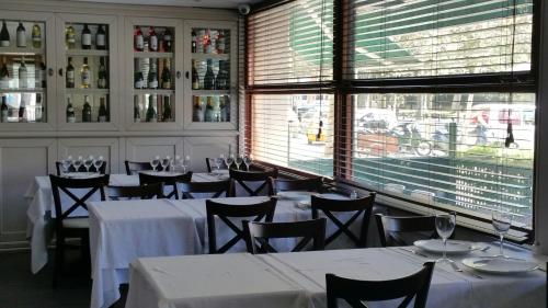 un ristorante con tavoli e sedie bianchi e finestre di La Ciudadela a Barcellona