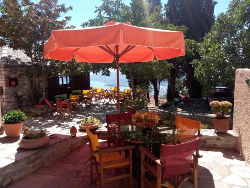 un tavolo con ombrellone rosso su un patio di Archontiko Pantou a Portariá