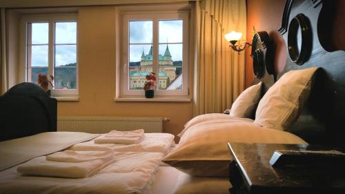 a hotel room with two beds and two windows at Hotel Bojnický vínny dom in Bojnice