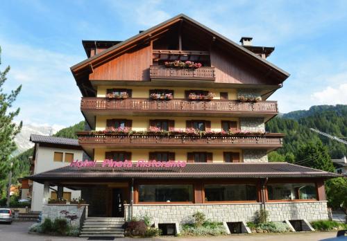 um grande edifício com varandas e flores em Hotel Pineta em Ponte di Legno