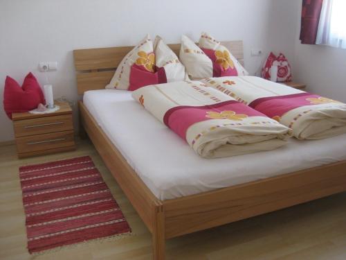 Un dormitorio con una gran cama de madera con almohadas en Apartment Galtenberg, en Alpbach