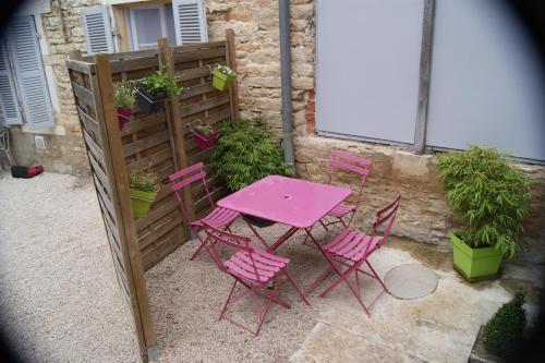 uma mesa rosa e cadeiras ao lado de uma cerca em Gite le murger em Meursault