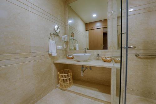 a bathroom with a sink and a shower at Kiscol Grands Hotel in Coimbatore