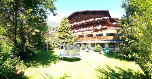 um grande edifício com um parque infantil em frente em Hotel Rogen em Neustift im Stubaital