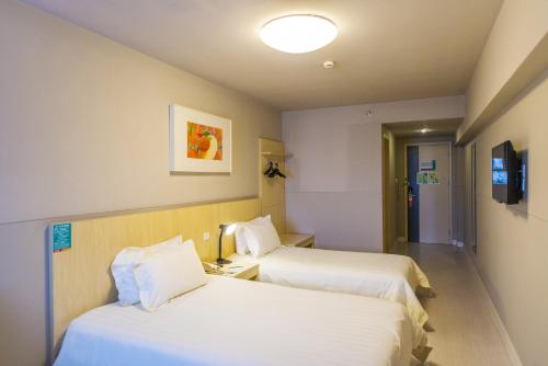 A bed or beds in a room at Jinjiang Inn Select Harbin Linye University Wenchang Street