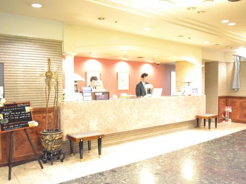 een man aan de balie van een restaurant bij Hotel Crown Hills Koriyama in Koriyama