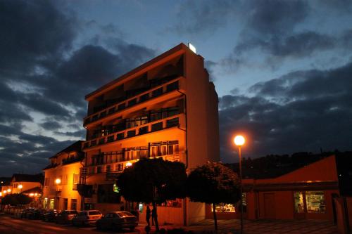 a tall building with cars parked in front of it at Hotel Krystal in Luhačovice