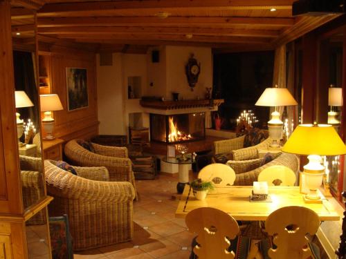 - un salon avec une table, des chaises et une cheminée dans l'établissement Hotel Caprice - Grindelwald, à Grindelwald