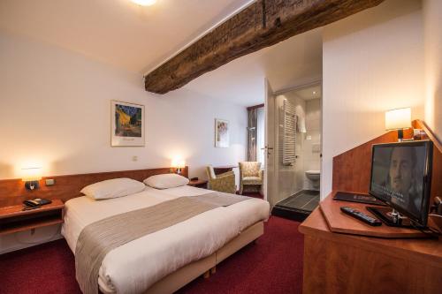 - une chambre avec un grand lit et une télévision dans l'établissement Hotel Restaurant in den Hoof, à Maastricht