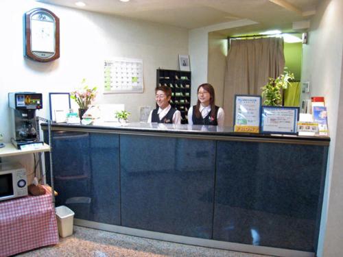 Due persone sedute al bancone in un negozio di Fuchu Urban Hotel a Fuchū