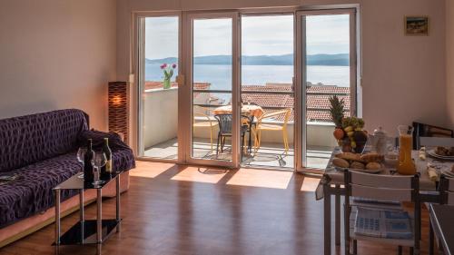 - un salon avec un canapé et une table avec un balcon dans l'établissement Villa Marina, à Omiš