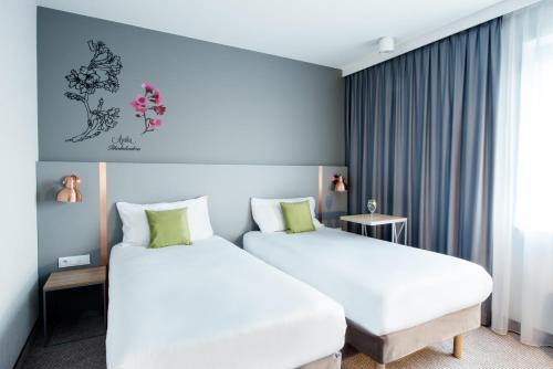 ein Hotelzimmer mit 2 Betten und einem Fenster in der Unterkunft ibis Styles Siedlce in Siedlce