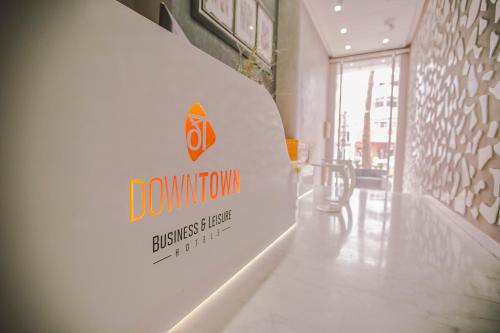 卡萨布兰卡Hôtel Down Town Maarif的建筑物白色长凳后面的标志