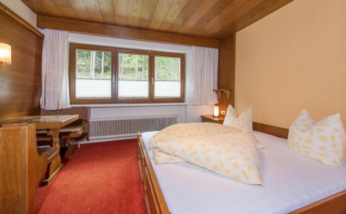 a bedroom with a bed and a desk and a desk at Apart Alpen in Längenfeld