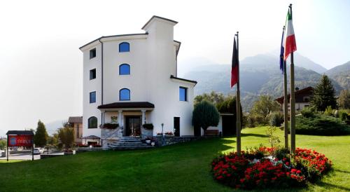 un edificio blanco con flores en el césped en Hotel Diana Jardin et Spa, en Aosta