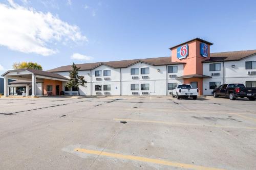 a large white building with a clock tower in a parking lot at Motel 6-Waterloo, IA in Waterloo