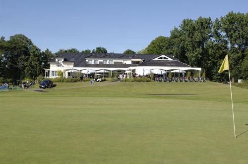 zieleń putting green z domem w tle w obiekcie Golfhotel Rheine Mesum w mieście Rheine